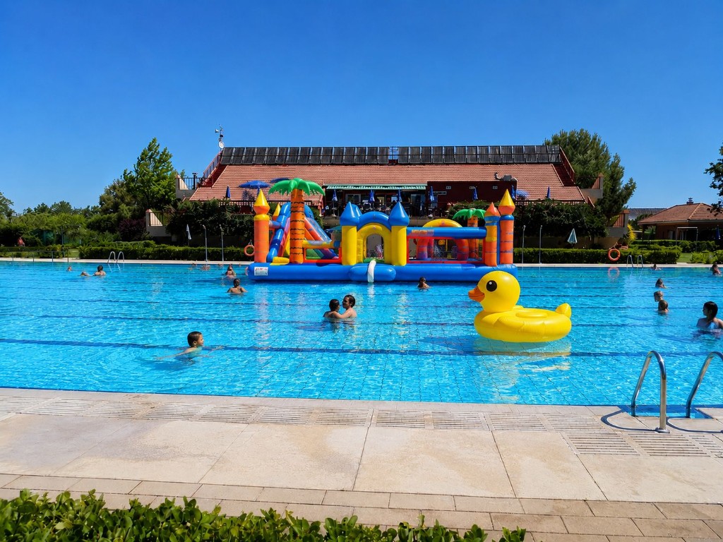 Piscina de Fuente La Mora con hinchables, castillo acuático y gente disfrutando del verano